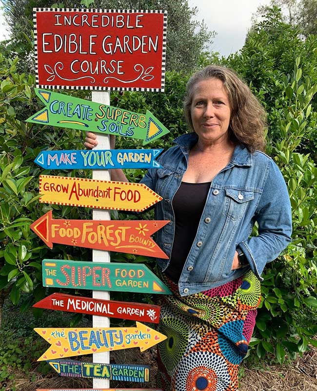 Morag Gamble standing beside an Incredible Edible Garden course sign