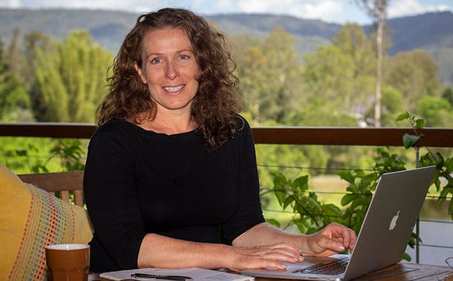 Morag at her computer, working on permaculture marketing to promote her business.